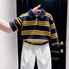 Ropa infantil estilo coreano 2026 colección otoño e invierno nueva: Suéter de punto con cuello polo a rayas azul marino y pantalones casuales blancos para niños