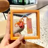 Etiqueta acrílica con texto de girasol creativo Colgante de llavero con campana Estudiante femenina Mochila escolar Colgante pequeño Venta al por mayor