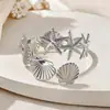 Pulseira de Braço Estilo Metal Europeu e Americano Cruzado Estrela Concha para Mulheres, Pulseira Fashion Estilo Férias, Joia de Luxo Leve de Alta Qualidade