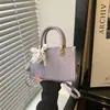 Bolso bandolera elegante y chic de un solo hombro, con un diseño minimalista y una forma pequeña y cuadrada.. Esta es la colección de verano 2026 de bolsos de mujer de moda