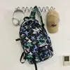 Nueva mochila escolar transfronteriza para hombre, gran capacidad, adecuada para secundaria y preparatoria, mochila con graffiti moderna y versátil, mochila deportiva y de viaje para mujer