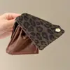 Coleção Outono/Inverno 2026: presilha de cabelo de pelúcia com design de tubarão para a parte de trás da cabeça, criando um look estiloso e retrô em uma sofisticada cor marrom, adequada para mulheres
