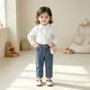 Conjunto sencillo de dos piezas para niña: Camisa blanca de un solo color, con cuello y manga larga, y pantalones de mezclilla, adecuada para primavera y otoño, estilo casual para niños pequeños.