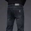 Jeans masculinos slim-fit pretos e cinzas de alta qualidade para o Outono/Inverno 2026, calças compridas casuais trendy e elásticas com forro de fleece