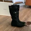 Botas altas de punta con interior elevador de altura, tacón de 4 cm, diseño de nicho y detalles fruncidos.