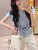 Tricô Irregular com Gola Redonda e Manga Curta para Mulheres Verão 2026 Novo Estilo Design Moderno e Elegante Top Curto que Marca a Cintura