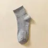 Medias clásicas en blanco y negro y gris para hombre y mujer, de color liso, con cintura antideslizante, de tubo medio, para deportes, informales, transpirables, de algodón.