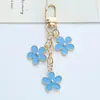 Nuevo llavero colgante de flor colorida ins, creativo, aleación DIY, flor pequeña de doble cara, decoración para funda de auriculares, bolso