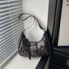 Bolsa de axila dulce y genial estilo motocicleta, nueva colección otoño 2026, bolso bandolera de un solo hombro, adecuado para el trabajo y los desplazamientos, con diseño de media luna tachonado