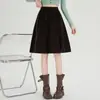 Foto real de falda midi de pana vintage para mujer, nuevo estilo otoño 2026, cintura elástica, línea A, adelgazante, falda de paraguas versátil