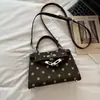 Bolsa Kelly feminina versátil nova 2026, luxo leve, moderna, nicho, quadrada pequena, para o trabalho, bolsa de mão com poá