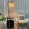 Mesa de noche de madera maciza de lujo con un diseño integrado de estilo vintage, creando una atmósfera de alta gama en el dormitorio, y una lámpara de pie de luz cálida junto al sofá de la sala de estar.