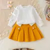 Ropa de primavera y otoño para niña de 26 años, sudadera de color liso con lazo y falda corta plisada, conjunto de bebé elegante y a la moda directamente de la fábrica fuente