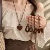 Cadena de suéter con lazo en forma de corazón de estampado de leopardo retro, un diseño único y elegante, con un collar largo geométrico de color café, creando un accesorio chic y atmosférico para mujer