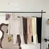 Top versátil de otoño e invierno: una capa base de punto elástico ajustada con un cuello alto pequeño, cortes en forma de gota de agua y mangas de encaje, perfecta como capa interior para otoño e invierno