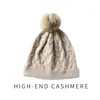 Cachemira Otoño/Invierno 2026 Nuevo Sombrero de Punto Versátil para Mujer con Pompón, Protección para los Oídos, Tejido de Cable, para Maternidad y Posparto, Sombrero Cálido de Punto
