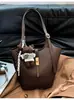 2026 nuevo bolso de mano de estilo retro de alta gama para mujer, versión coreana, bolso de hombro súper popular, bolso simple de axila, bolso tipo cubo versátil, moderno