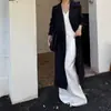 Foto real del nuevo abrigo negro elegante de otoño 2026, gabardina de longitud media holgada con cinturón para mujer