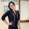 Conjunto de punto de dos piezas estilo preppy para mujer: Cárdigan de punto con rayas de bloques de color, cuello en V, cuello tipo polo, sin mangas y una falda corta ajustada