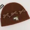 Gorro de punto de estilo coreano inspirado en la dopamina con un lazo, diseñado para mujeres, que proporciona calor y protección para los oídos en otoño e invierno, y favorece el rostro; un sombrero pequeño y elegante para estudiantes