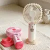 Ventilador de mano nuevo, simple y elegante, con rociador hidratante y tres velocidades de viento, que cuenta con una base de carga directa para teléfono, perfecto como ventilador de escritorio y como regalo