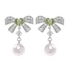 Únicos y elegantes, estos dulces pendientes de lazo con incrustaciones de diamantes y perlas exudan un aura elegante y sofisticada, ofreciendo un toque de lujo y versatilidad para cualquier atuendo.