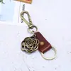 Regalos pequeños hechos a mano creativos llavero de aleación hueca rosa cuero joyería para hombres comercio electrónico transfronterizo suministro