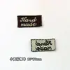 Logotipo de fábrica se puede pedir accesorios para el cabello material marca registrada hecha a mano parche marca tejida etiqueta de tela etiqueta impresa en inglés accesorios de joyería al por mayor