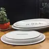 Venta directa de fábrica de platos ovalados para pescado de cerámica blanca pura con borde grueso, adecuados para uso en hoteles, restaurantes y cenas en casa.