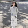 Elegante y a la moda conjunto de dos piezas para niñas para primavera y otoño: un top a rayas con un diseño de cuello único, combinado con pantalones casuales con delicados detalles de encaje - un conjunto de dos piezas moderno