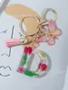 Suministros del Fabricante Llaveros con Flores Secas Prensadas 26 Letras del Alfabeto Inglés Llaveros con Borla de Mariposa Charms para Bolsos de Mujer
