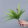 Plantas verdes artificiales en stock, manojos de helecho, hojas de helecho, hierba de helecho para decoración de paredes interiores y diseño de paisajes, césped artificial al por mayor