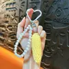 Pingente de chaveiro de corrente de pérolas de frutas simuladas, doce e versátil, design fresco e simples, moderno e único