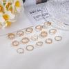 Anel de torção de pérola de vento europeu e americano de venda quente transfronteiriço com diamante Personalidade Rose Drop Oil 15 peças conjunto anel comum