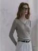 Camiseta única y de nicho de punto de sarga gris con cuello en V y manga larga para mujer, top casual de otoño de alta gama ajustado con hombros normales