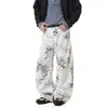 Calça casual de perna larga com estampa graffiti em tinta sobre fundo branco, solta, plissada, cintura alta, comprimento até o chão, com uma vibe descontraída