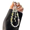 Elegante correa de cristal para teléfono móvil con forma de flor de ciruelo, con lazo tachonado de diamantes de imitación y borla, accesorio corto para bolso de muñeca