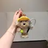 Llavero de peluche de cachorro de tenis deportivo, colgante de muñeco de perro teddy con sombrero amarillo, accesorio de bolsa de juguete deportivo casual