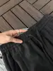 Calças cinza-escuras, texturizadas, estilo "old money" para homens, adequadas para o outono, com caimento clean, pregas, design de perna reta e uma estética americana retrô com caimento fluido.