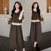 Novas roupas de maternidade para outono e inverno: um vestido colete de bolinhas para usar por cima, combinado com um conjunto de duas peças com detalhes em renda e design de amarrar para cobrir e dar suporte à barriga