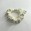 Goma para el pelo floral en forma de corazón, con un suave y texturizado tejido de satén en una paleta de colores apagados, con delicados detalles de encaje plisado para un look suave y refinado