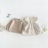 La nueva colección de invierno de Dianxi para bebés niñas incluye un conjunto de dos piezas: una camiseta básica de forro polar, engrosada y con mangas acampanadas, y un vestido chaleco acolchado de algodón con estampado floral.