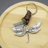 Llavero creativo para hombre de aleación con forma de libélula, estilo vintage de piel de vaca trenzada, de bronce.