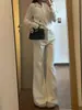 Jeans beige de mujer petite ligeramente acampanados, un estilo popular de otoño-verano, no se pegan a las piernas, estilizan, con una bonita caída, pantalones versátiles de largo hasta el suelo