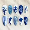 Unhas postiças azuis e brancas com tema oceânico, formato amêndoa, apresentando designs de polvo, tubarão-baleia, peixes, conchas, estrelas-do-mar e corais, unhas postiças de praia