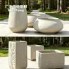 Vasos de cimento fosco com acabamento de areia não retêm facilmente manchas de água e são fáceis de manter, adequados para plantas grandes em vasos ao ar livre no terraço.