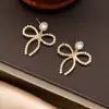 Pendientes de Botón de Perla y Lazo Elegantes de Moda Tongle Diseño de Nicho Cadena Triple Incrustada de Diamantes Pendientes Elegantes Venta al por Mayor