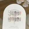Un Arte de Uñas Cat-Eye Fresco y Etéreo con Luz de Luna Azul Claro, Degradado Blanco Lechoso y Diamantes Tallados Que Realzan el Cutis