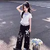 Conjunto de dos piezas a la moda estilo universitario para niños de mediana edad y mayores: camiseta polo de manga corta a rayas y patchwork y pantalones casuales anchos con ribete de encaje