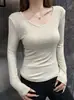 Nueva camiseta negra pura de manga larga con cuello en V para otoño e invierno para mujer, adecuada tanto para llevar sola como debajo de otra prenda, corte ajustado y que realza la figura.